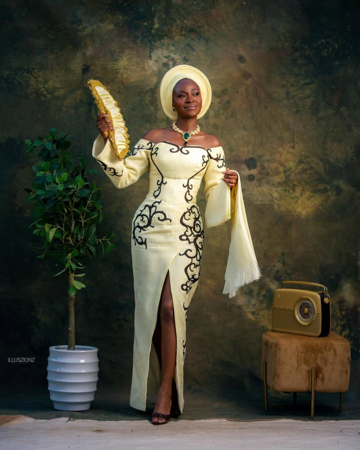 Ivory occasion gown with matching gele and fan