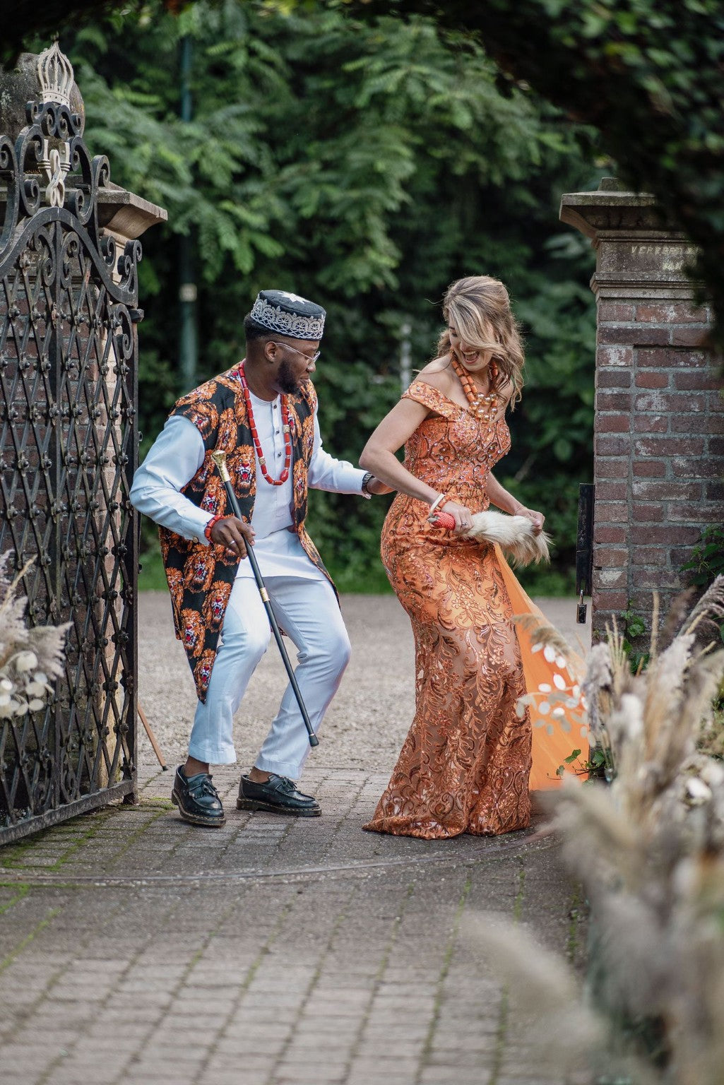 Wedding couple in coordinated orange and traditional-inspired occasionwear