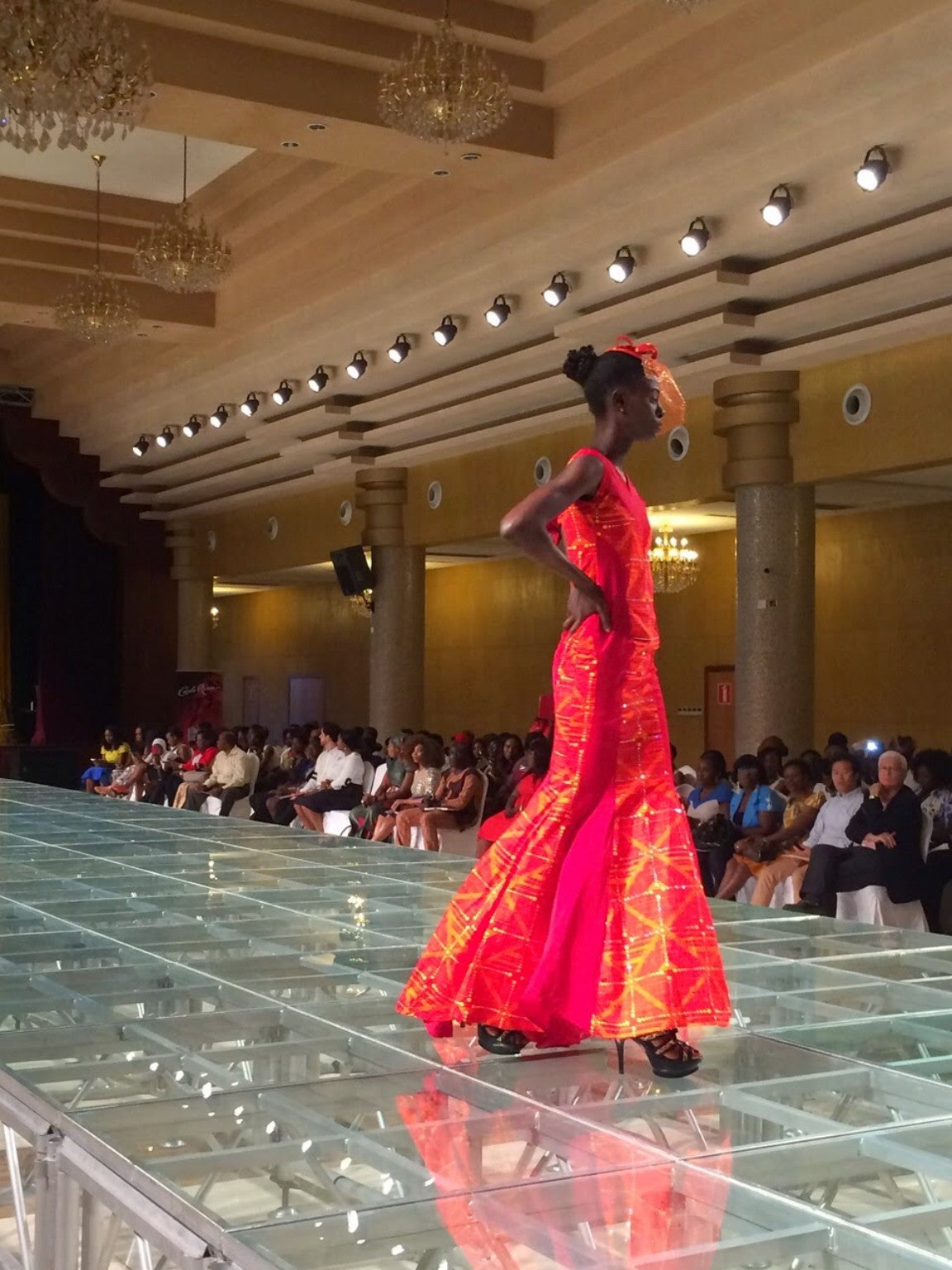Tolumi runway look in a red and orange floor-length gown