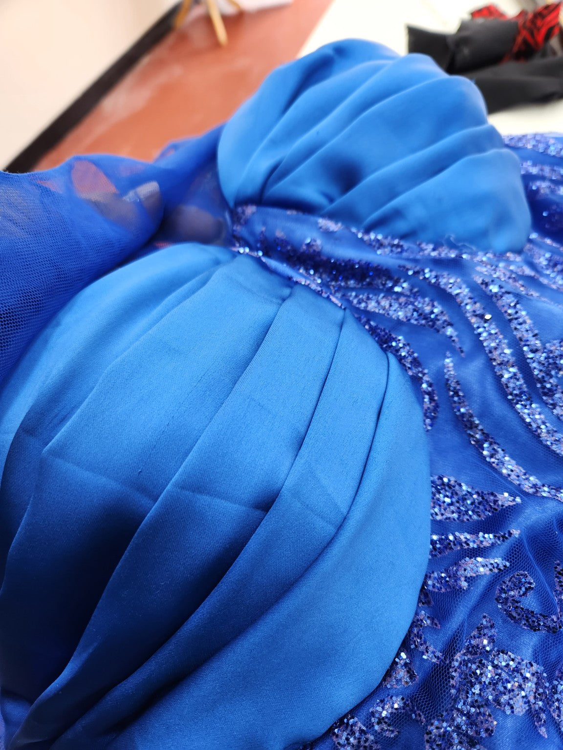 Close detail of blue draping and embellished fabric